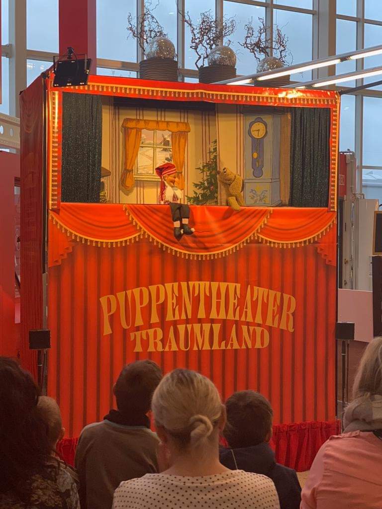 Publikum vor der orange-roten Bühne von Puppentheater Traumland