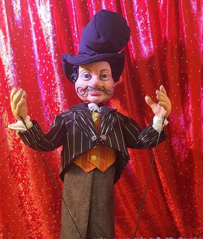 Handgefertigte Zirkusdirektor-Marionette vor rotem Vorhang