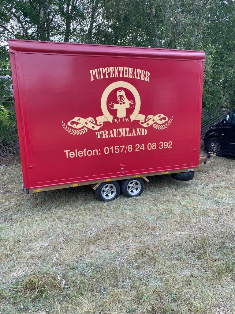Der Theaterwagen mit goldenem Logo und Telefonnummer